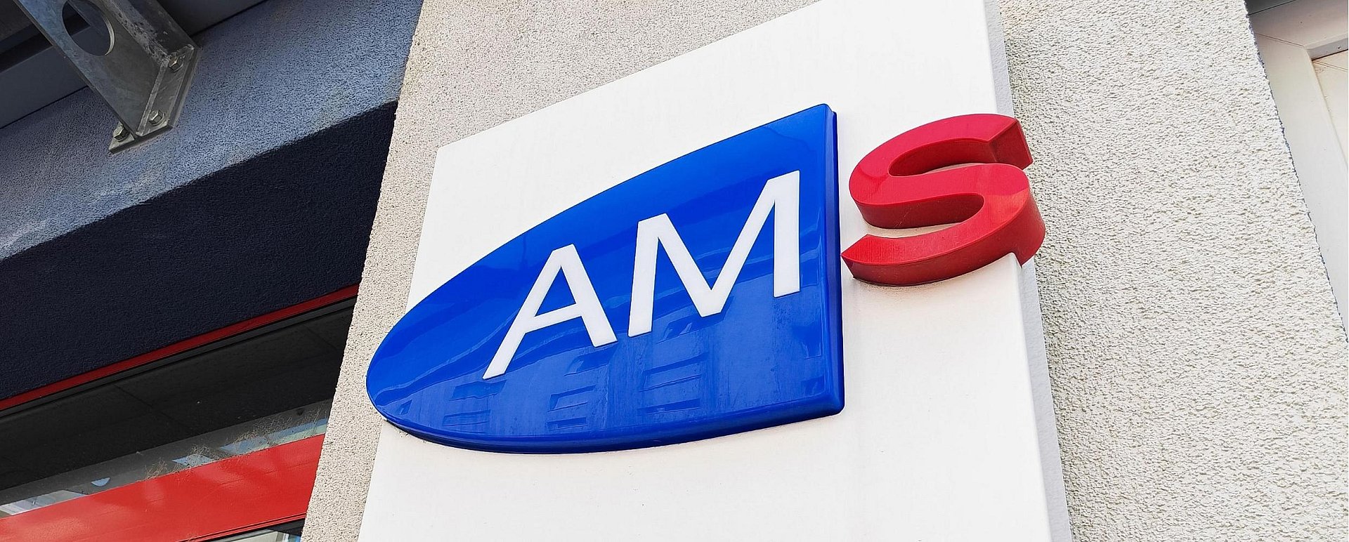 Schriftzug ”AMS” an einem Gebäude. Adobe Stock Foto